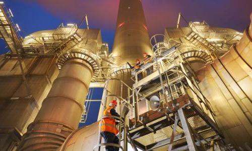 Workers at a coal fired plant climbing a ladder.