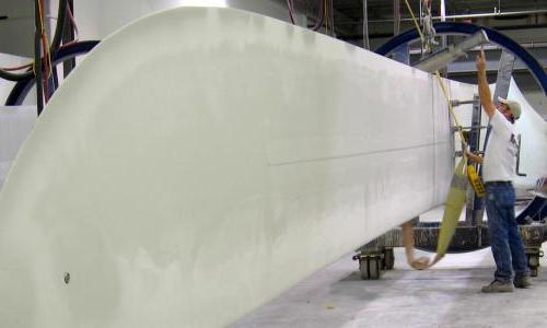 Two people working on a wind turbine blade.